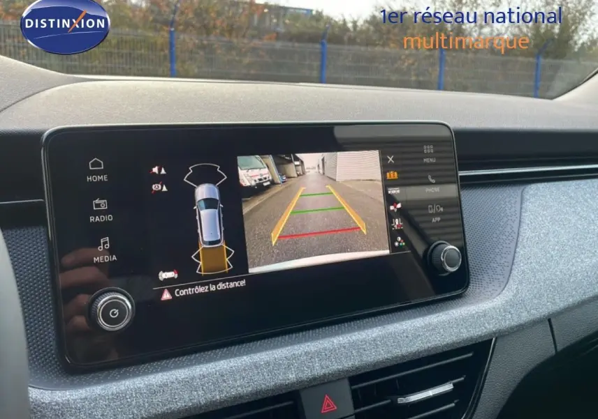 Écran tactile intérieur du Skoda Kamiq gris argent montrant la caméra de recul et l'aide au stationnement.