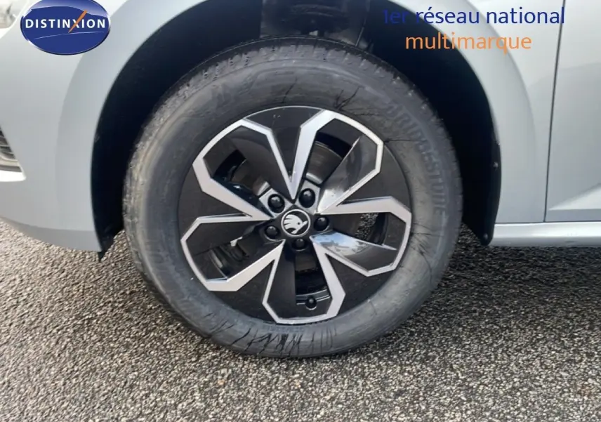 Gros plan sur la roue avant gauche d'un Skoda Kamiq gris argent métallisé avec jante alliage bicolore.