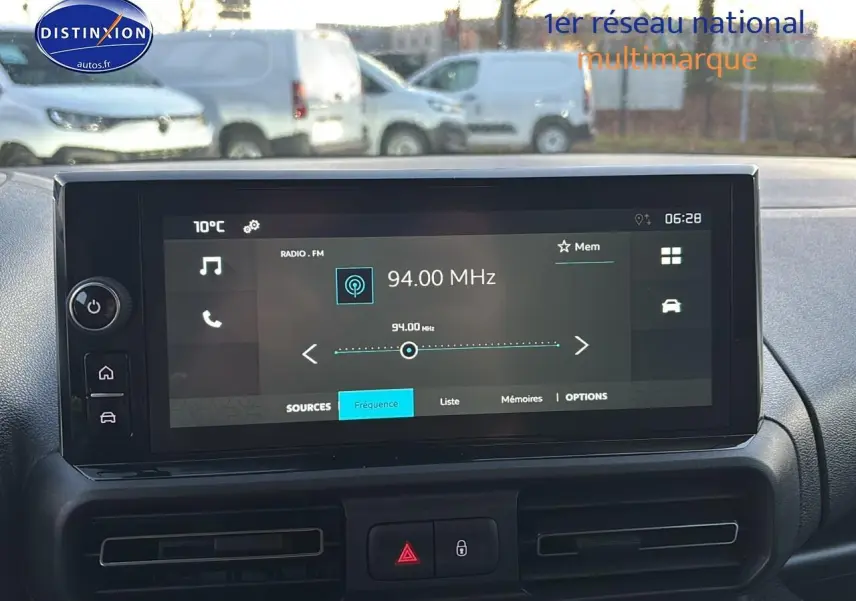 Vue avant intérieure sur l’écran tactile multimédia du Citroën Berlingo Fourgon blanc 2025 affichant une fréquence radio FM.