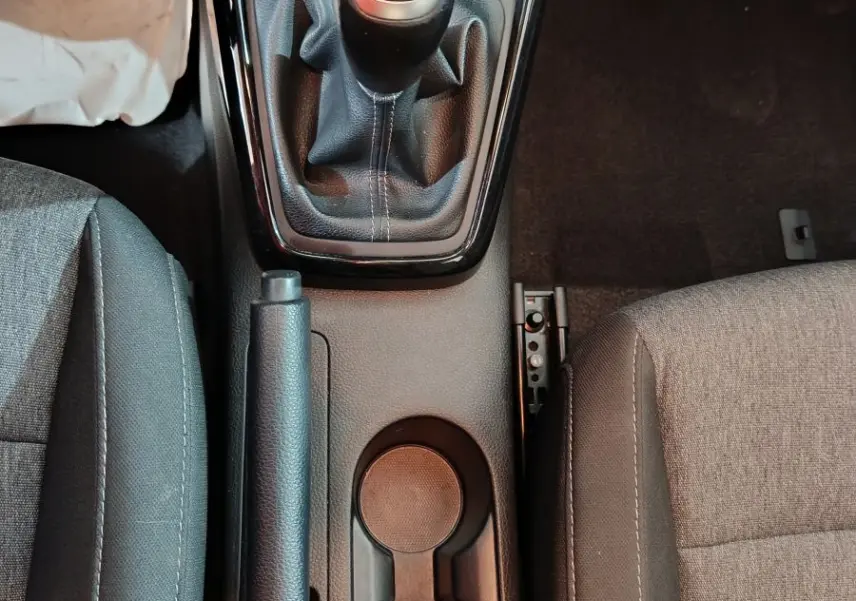 Vue plongeante sur la console centrale intérieure du KIA Stonic gris clair, montrant levier de vitesses manuel et frein à main.