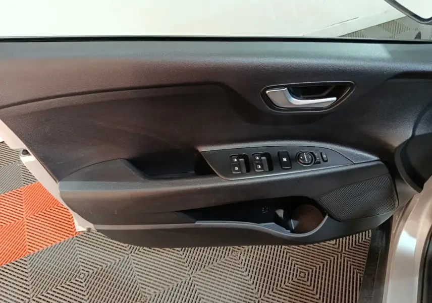 Vue rapprochée de la porte avant gauche noire du Kia Stonic gris clair, avec commandes électriques des vitres et rétroviseurs.