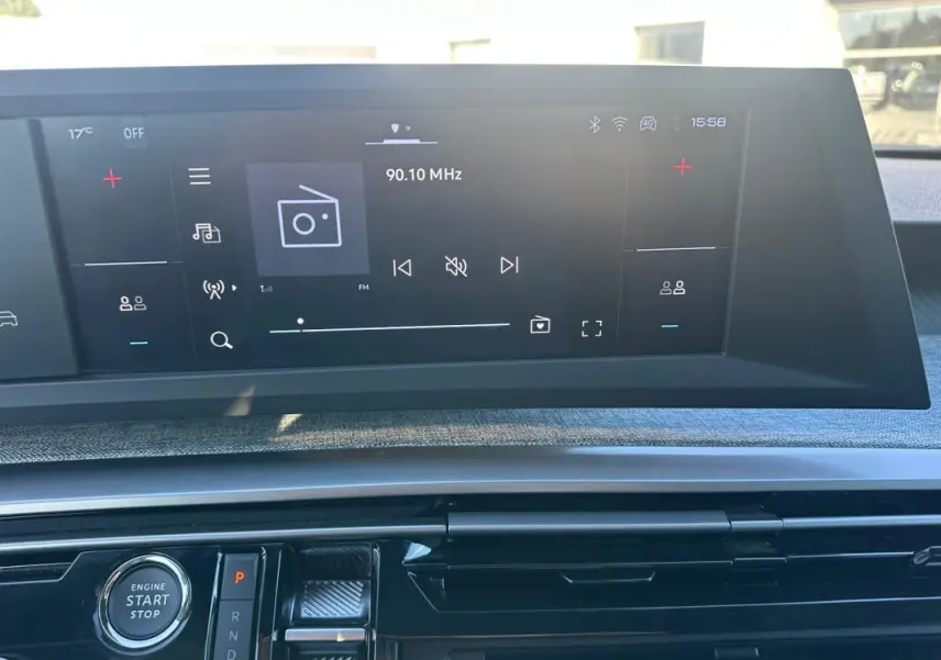 Vue rapprochée du tableau de bord numérique et de la console centrale du Peugeot 3008 Hybrid blanc 2025, avec écran tactile radio.