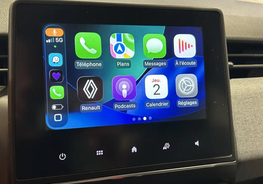 Écran tactile central de la Renault Clio V affichant l’interface Apple CarPlay avec plusieurs applications colorées.