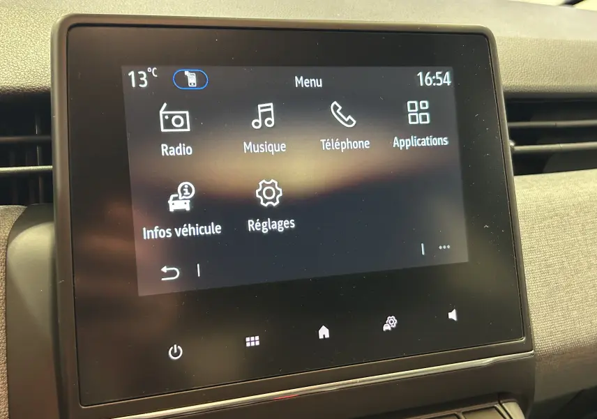 Écran tactile central de la Renault Clio V gris schiste, affichant le menu principal avec options radio et téléphone.