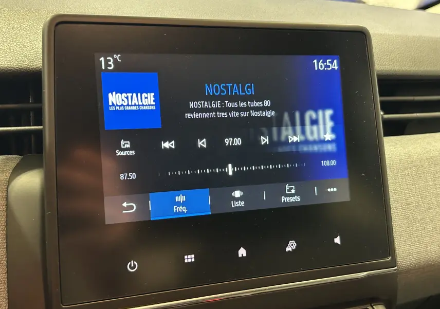 Écran tactile central de la Renault Clio V affichant la radio Nostalgie à 97.00 FM, intérieur noir et gris.