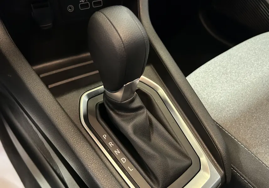 Le levier de vitesse automatique noir de la Renault Clio V TCE 90CH, entouré de garnitures grises et tissu clair adjacent.