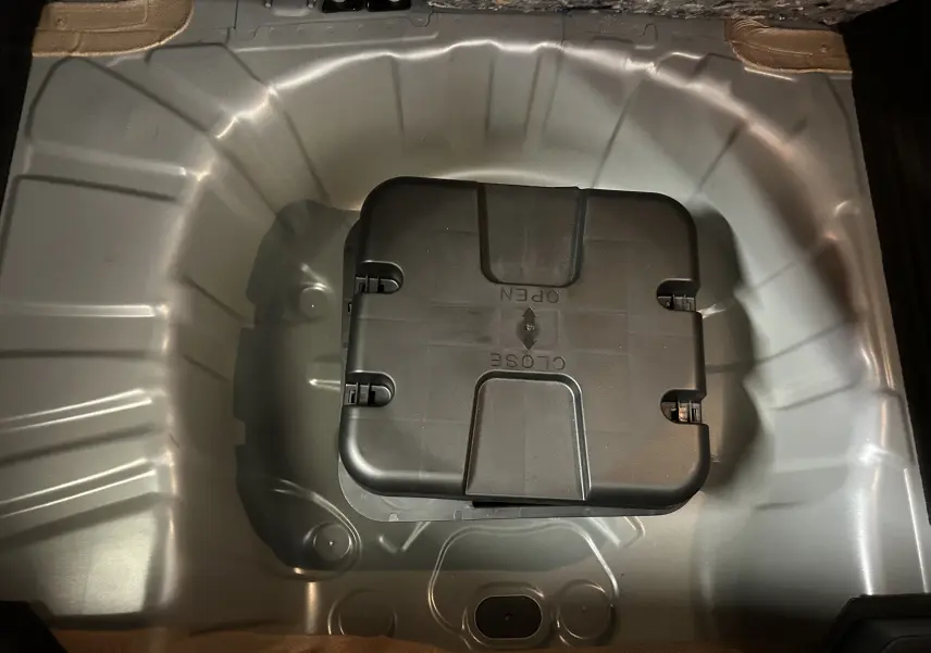 Coffre à roue de secours vide de Renault Clio V 2025, vue plongeante sur compartiment gris métallisé.