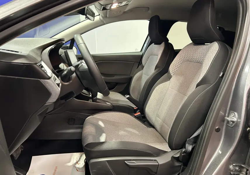 Vue intérieure côté conducteur de la Renault Clio V gris schiste, sièges tissu bicolore gris et noir, volant multifonction.