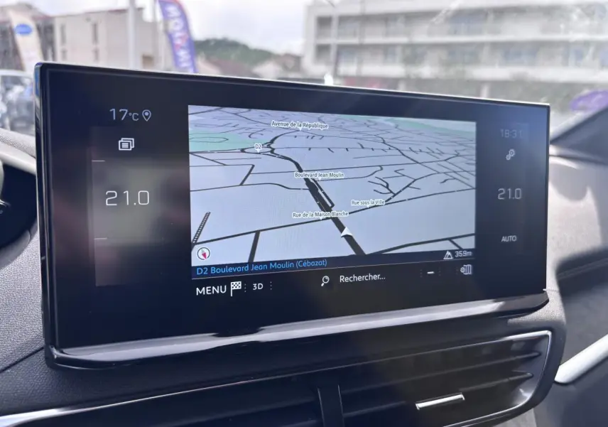 Écran tactile du système de navigation du Peugeot 5008 blanc, vue intérieure centrée sur la console centrale.
