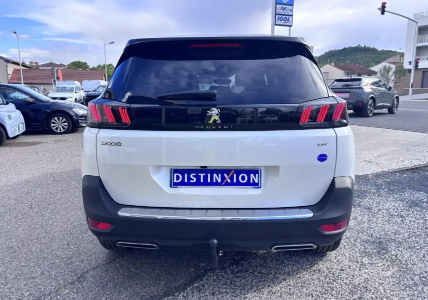 Vue arrière d'un Peugeot 5008 blanc GT 2022 avec feux arrière distinctifs et attelage visible.