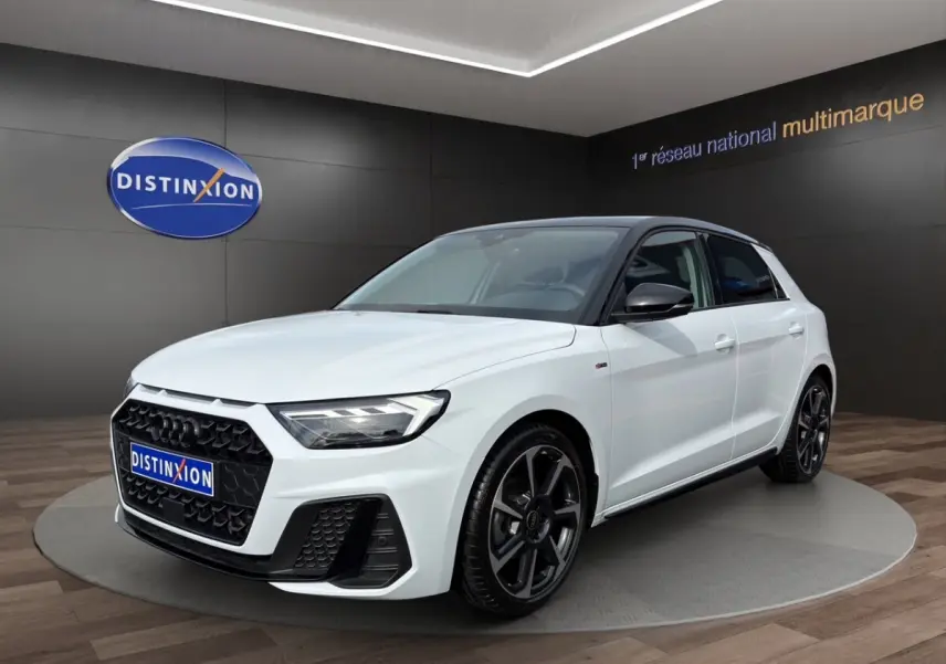Audi A1 Sportback blanc vue 3/4 avant avec toit noir et jantes noires en exposition showroom.