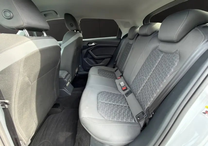Vue intérieure côté droit des sièges arrière gris avec motifs géométriques d'une Audi A1 Sportback blanche 2025.