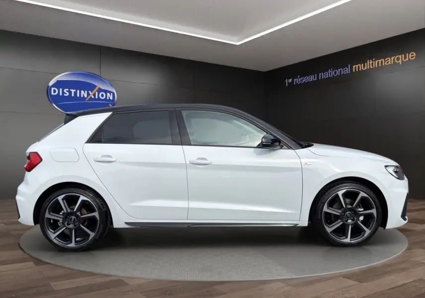 Audi A1 Sportback blanc vue de profil côté gauche, avec toit noir et jantes alliage distinctives.