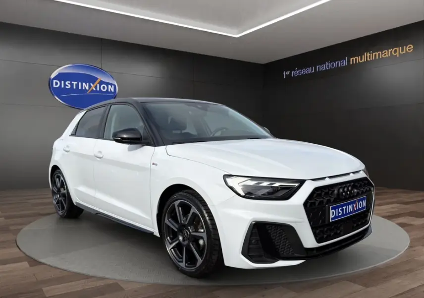 Audi A1 Sportback blanc vue 3/4 avant avec toit noir et jantes alliage noires en showroom.