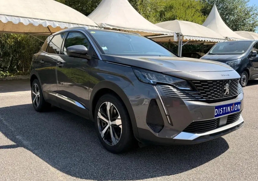 Peugeot 3008 gris platinium en 3/4 avant droit, avec calandre noire et jantes alliage bicolores.