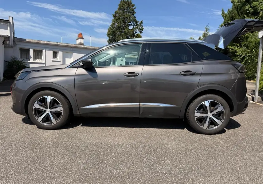 Peugeot 3008 gris platinium vue de profil côté gauche, hayon arrière ouvert et jantes bi-ton visibles.