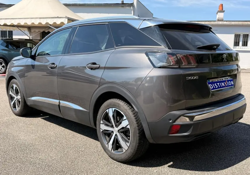 Peugeot 3008 gris platinium en 3/4 arrière droit, soulignant ses feux arrière distinctifs et jantes bi-ton.