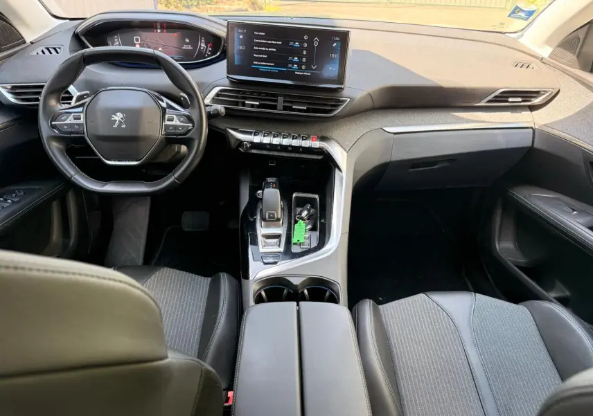 Vue intérieure avant du Peugeot 3008 2021, tableau de bord moderne avec écran tactile et volant compact noir.