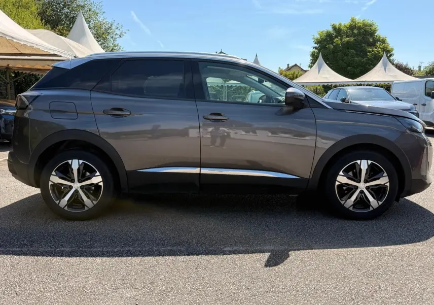 Peugeot 3008 gris platinium vue de profil côté gauche, soulignant ses jantes bicolores et lignes épurées.