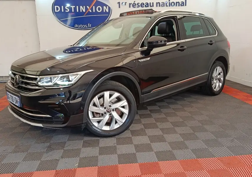 Volkswagen Tiguan noir hybride rechargeable vu en 3/4 avant droit, avec jantes alliage et badge eHybrid visible.