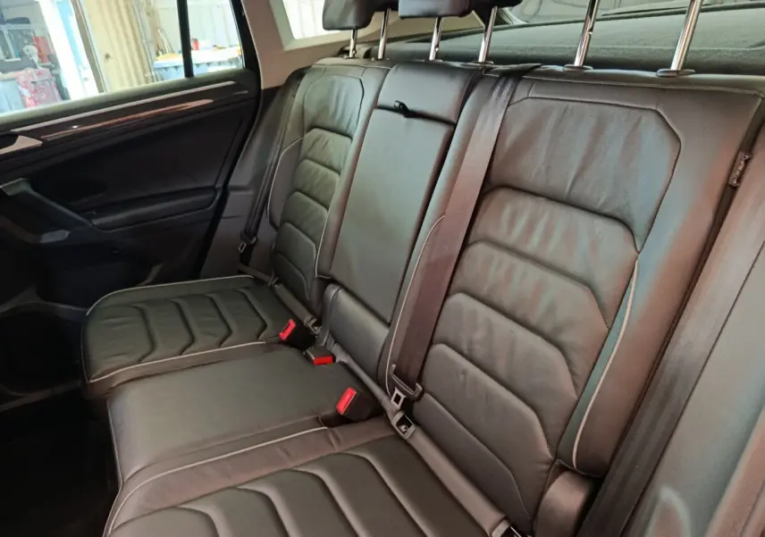 Vue intérieure côté gauche sur la banquette arrière noire en cuir du Volkswagen Tiguan 1.4 eHybrid 2022.
