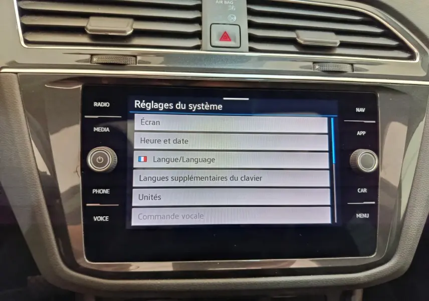 Vue rapprochée de l'écran tactile central du Volkswagen Tiguan noir, affichant les réglages du système.