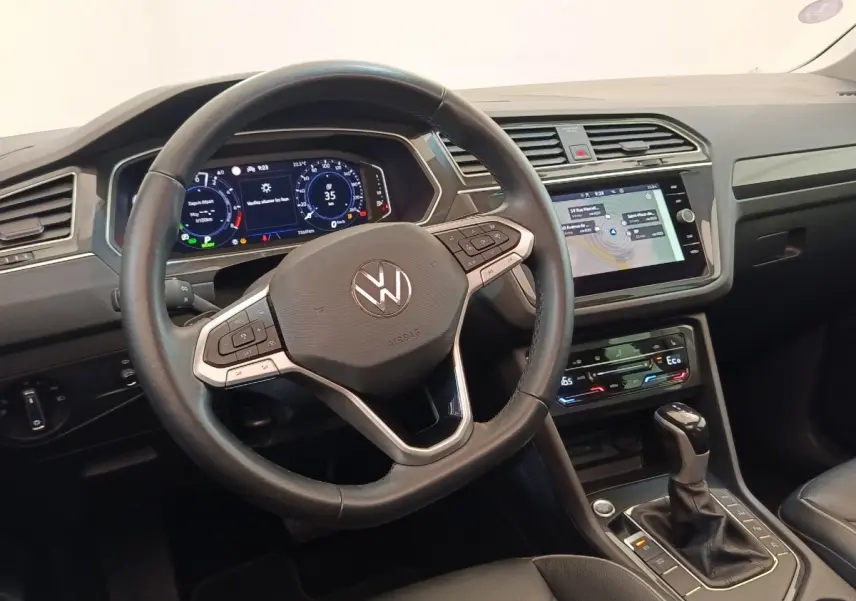 Vue intérieure du tableau de bord et volant noir du Volkswagen Tiguan 1.4 eHybrid 2022 avec écran tactile central.