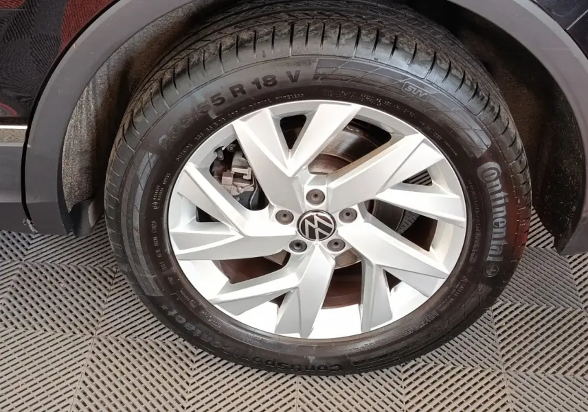 Gros plan sur la roue avant droite du Volkswagen Tiguan noir, mettant en valeur la jante alliage argentée et le pneu Continental.