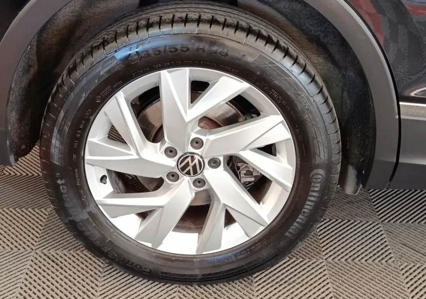 Gros plan sur la roue avant droite avec jante argentée du Volkswagen Tiguan noir 1.4 eHybrid 2022.