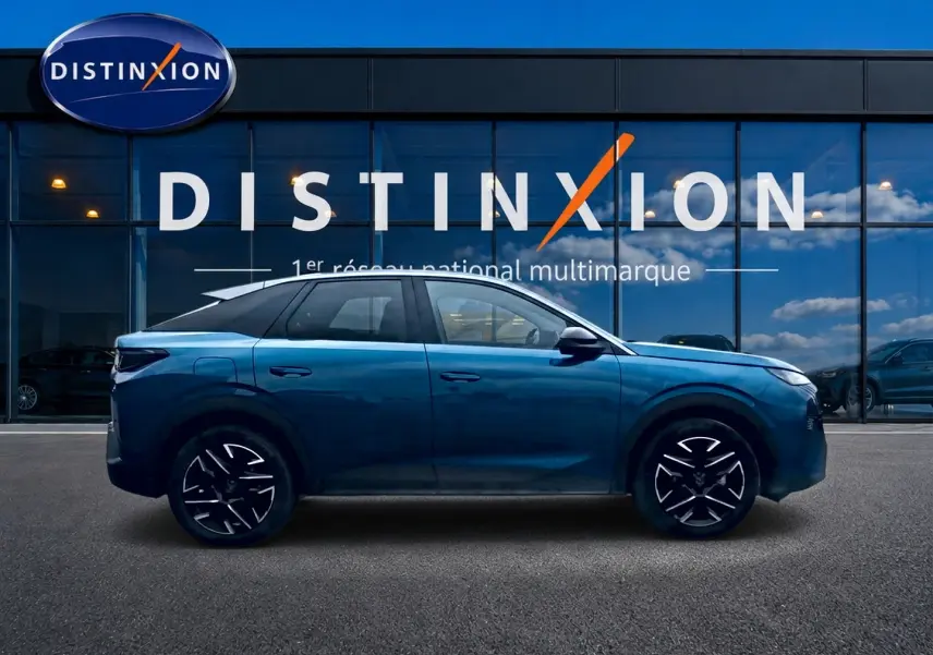 Profil côté gauche du Peugeot 3008 bleu 2025 avec jantes alu et toit noir devant une vitrine Distinxion.