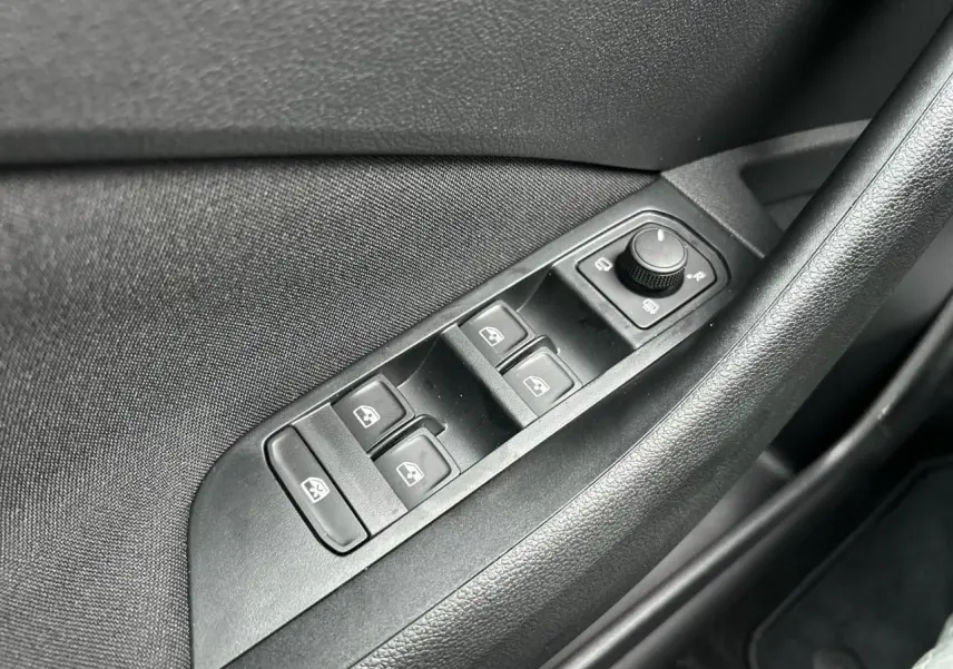 Gros plan sur la commande des vitres électriques côté conducteur du Skoda Kamiq noir Magic, intérieur tissu noir.