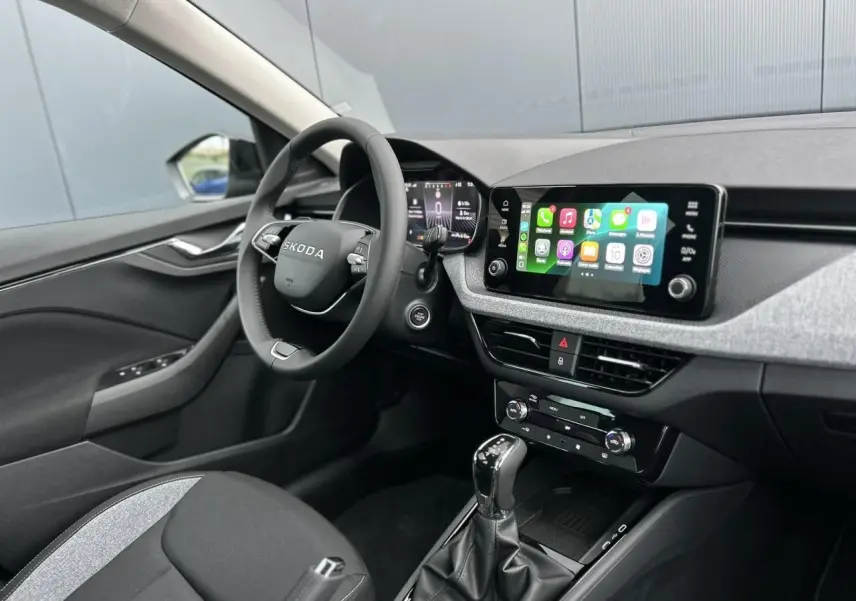 Intérieur avant gauche du Skoda Kamiq 2025, volant multifonctions noir et écran tactile Apple CarPlay visible.