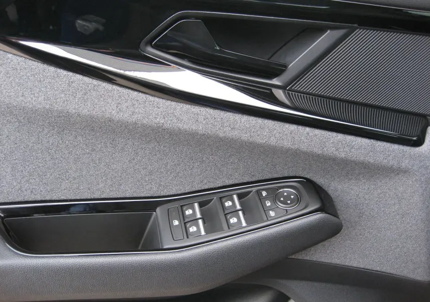 Détail de la porte côté gauche du Renault Austral 2025 bleu iron, montrant les commandes des vitres et la poignée intérieure.