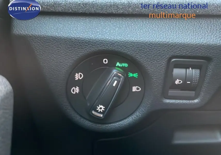 Gros plan sur le sélecteur de phares automatique du tableau de bord d’un Skoda Kamiq gris argent.