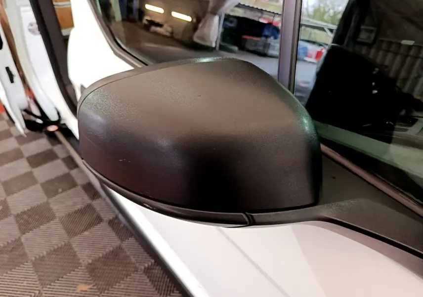 Gros plan sur le rétroviseur côté gauche du Ford Transit Fourgon blanc, avec porte ouverte en arrière-plan.