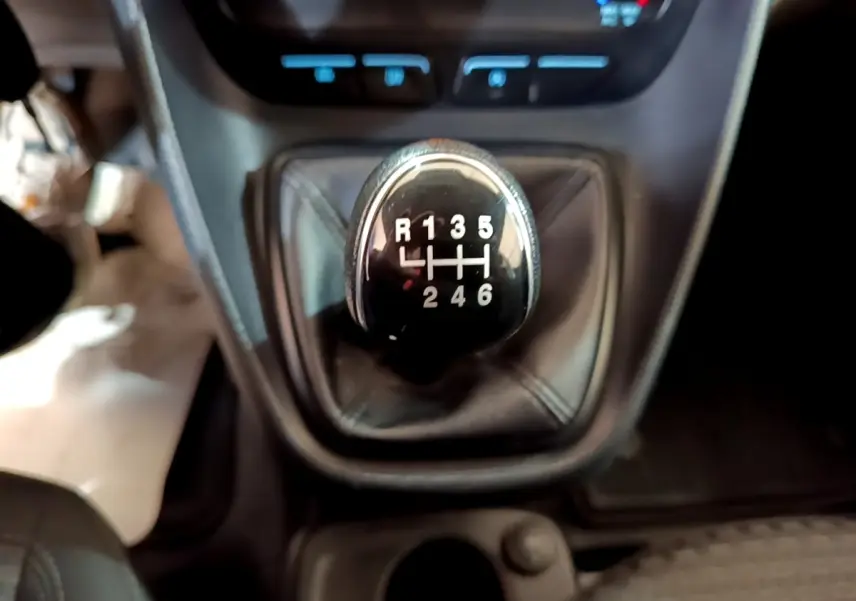 Gros plan sur le levier de vitesses manuel noir du Ford Transit Fourgon blanc, intérieur sombre.