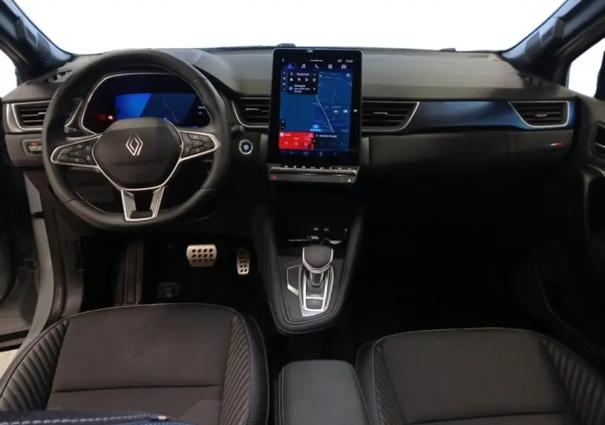 Vue intérieure frontale du tableau de bord noir du Renault Symbioz E-Tech avec écran tactile vertical et volant multifonction.