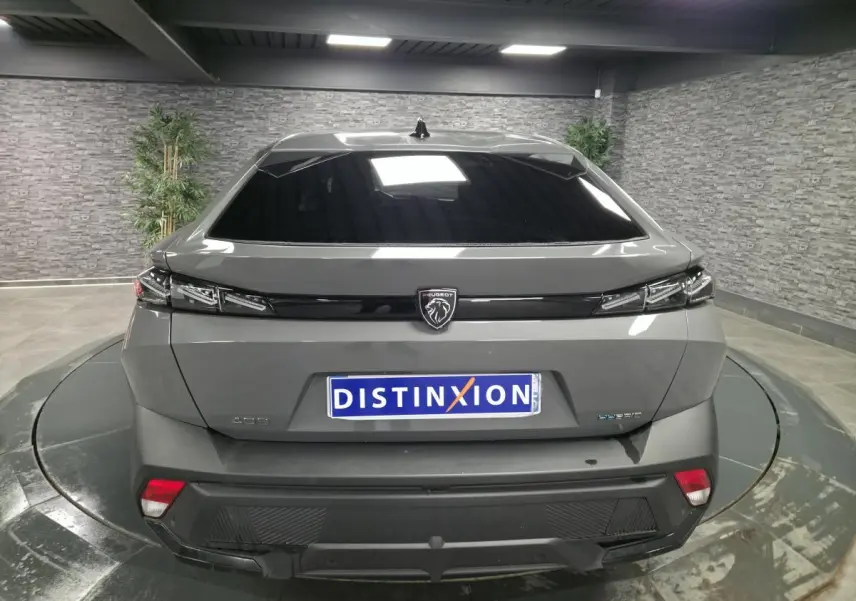 Vue arrière d'une Peugeot 408 gris métallisé avec feux arrière à LED et logo lion central noir brillant.