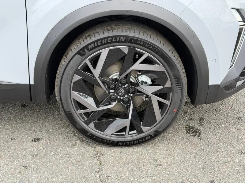 Gros plan sur la roue avant droite du Renault Captur 2026 gris Rafale, jante alliage noire et argent au design géométrique.