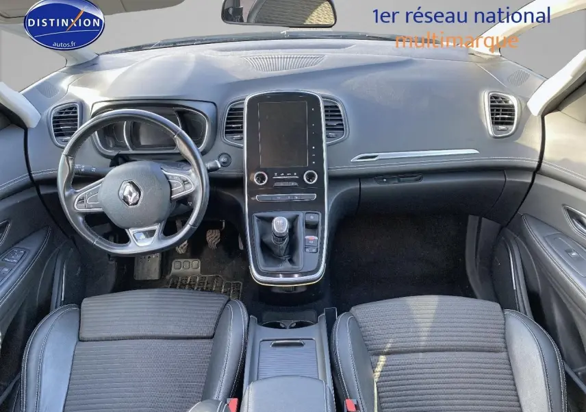 Vue intérieure avant du Renault Grand Scenic IV 2019, tableau de bord avec écran tactile vertical et volant cuir noir.
