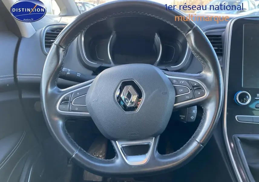 Volant cuir noir Renault Grand Scenic IV vu de face avec commandes intégrées et tableau de bord partiellement visible.