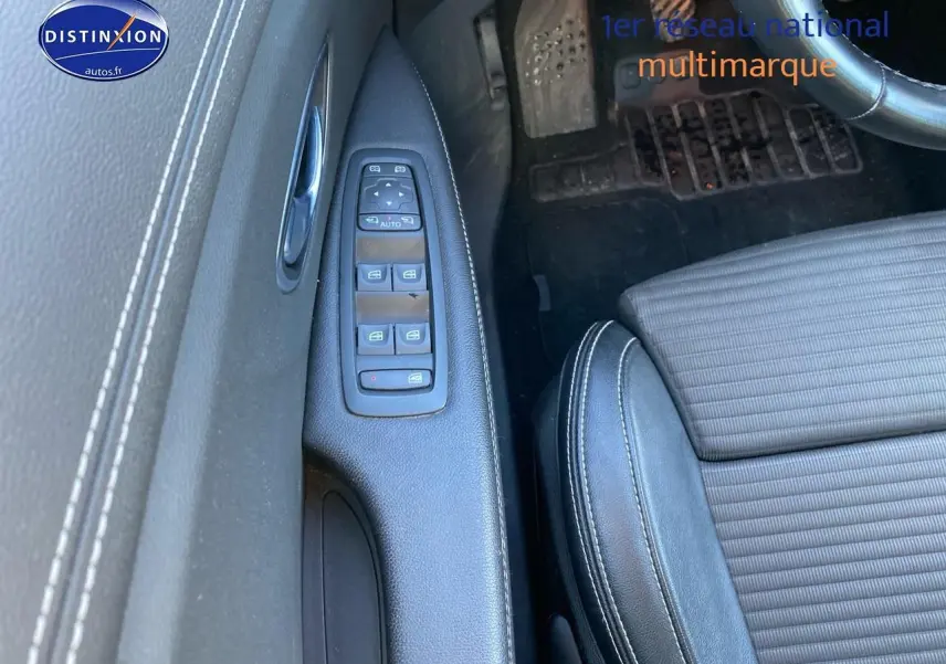 Vue rapprochée de la porte avant gauche d’un Renault Grand Scenic IV 2019, avec commandes de vitres et sellerie noire.