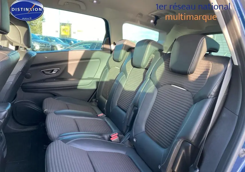 Vue latérale des sièges arrière en similicuir noir du Renault Grand Scenic IV bleu, avec appuie-têtes et ceintures visibles.