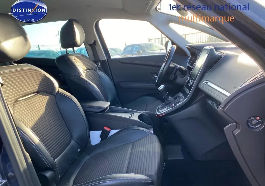 Vue intérieure côté conducteur du Renault Grand Scenic IV bleu 2019, avec sièges en similicuir noir et écran tactile vertical.