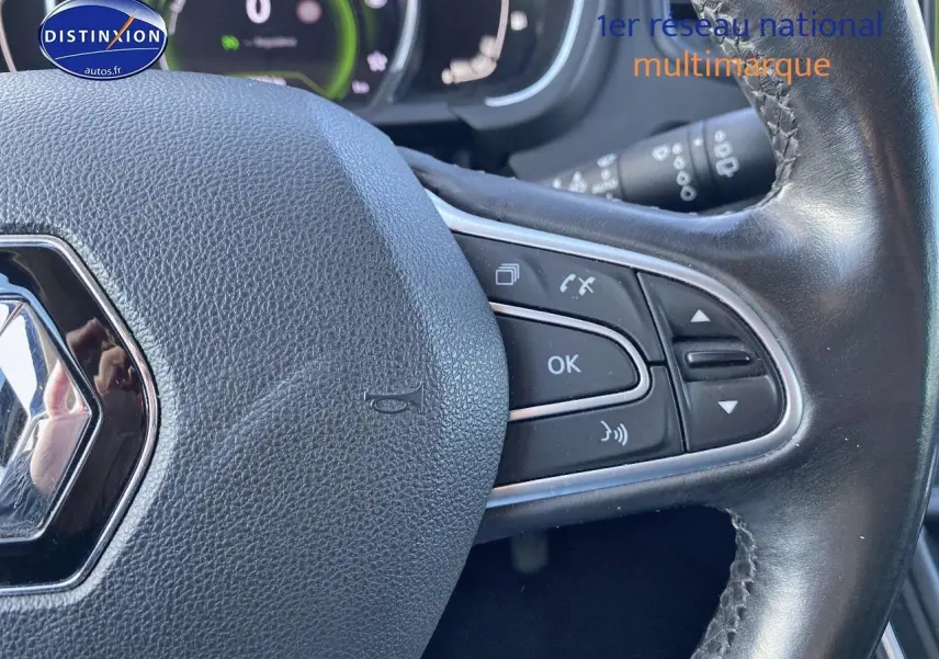 Gros plan sur le volant cuir noir du Renault Grand Scenic IV bleu, avec commandes multifonctions visibles à droite.
