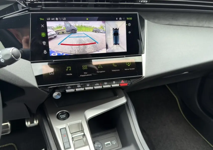 Vue intérieure du tableau de bord de la Peugeot 308 2026 avec écran tactile affichant la caméra de recul et console centrale.