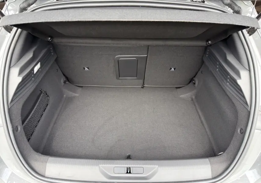 Coffre ouvert vu de dessus de la Peugeot 308 gris clair, espace de rangement spacieux et tapis noir.