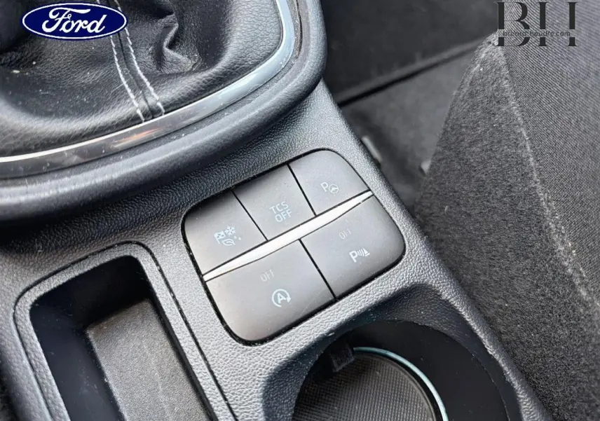 Gros plan sur la console centrale noire du Ford Puma 2023, montrant les boutons de contrôle près du levier de vitesse.
