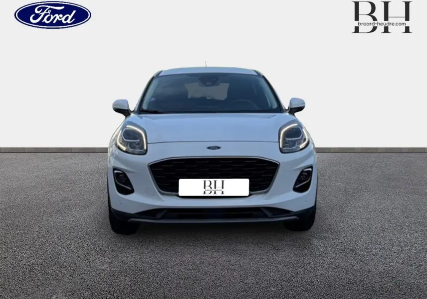 Vue frontale d'un Ford Puma blanc Glacier avec phares LED allumés et calandre noire distinctive.
