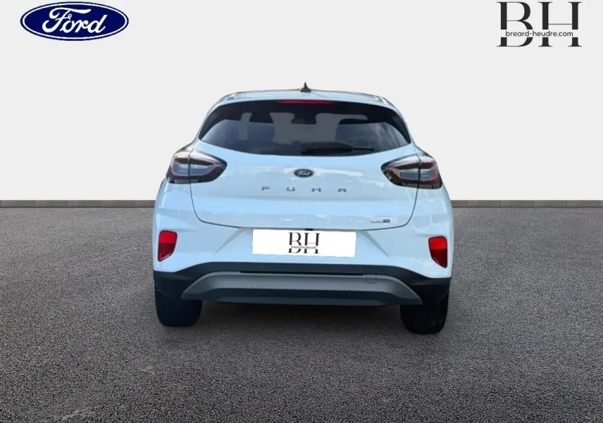 Vue arrière d'une Ford Puma blanc glacier 2023 avec hayon électrique et feux arrière LED sur fond neutre.